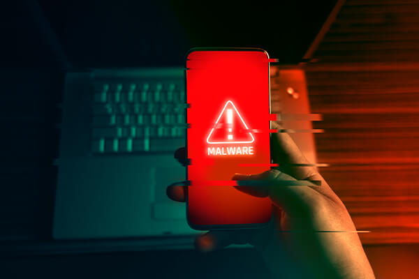 Hand holding smartphone with a malware warning on it. Information security services can help you avoid a cyberattack