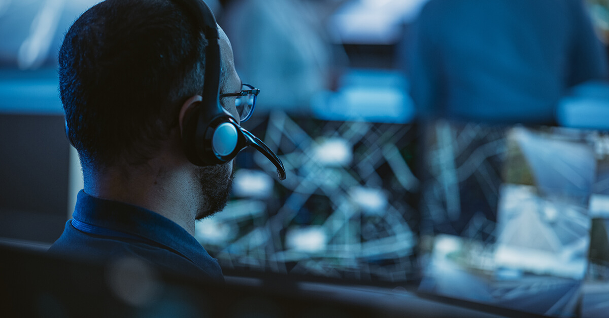 IT professional with headset in a monitoring center