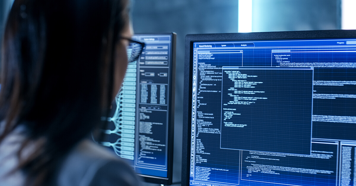 Female IT engineer working with multiple displays.