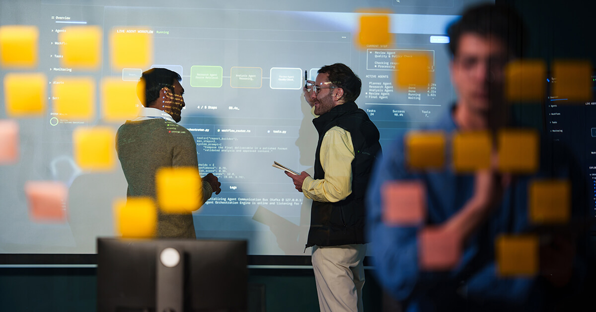 IT professionals reviewing a digital workflow and system processes during a technical planning session.