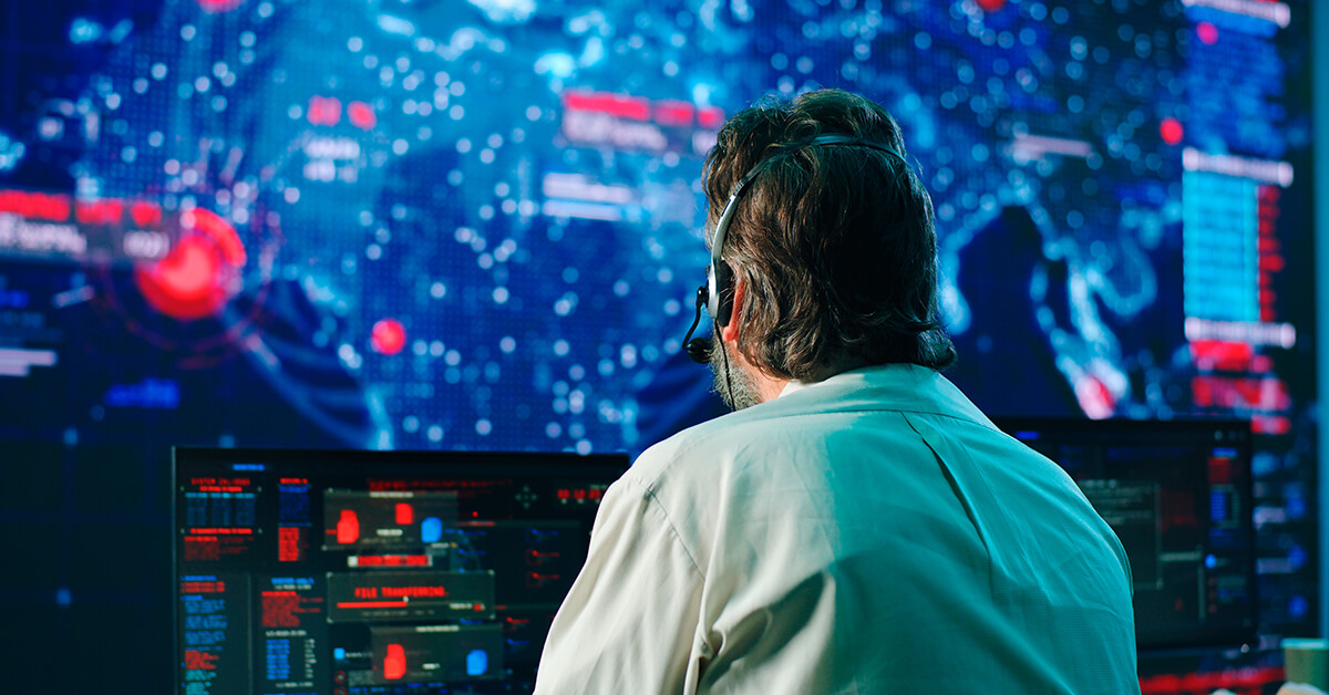 Cybersecurity analyst monitoring threat activity across multiple screens in a security operations center.