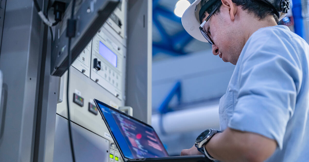 Manufacturing engineer monitoring industrial control systems and production equipment.