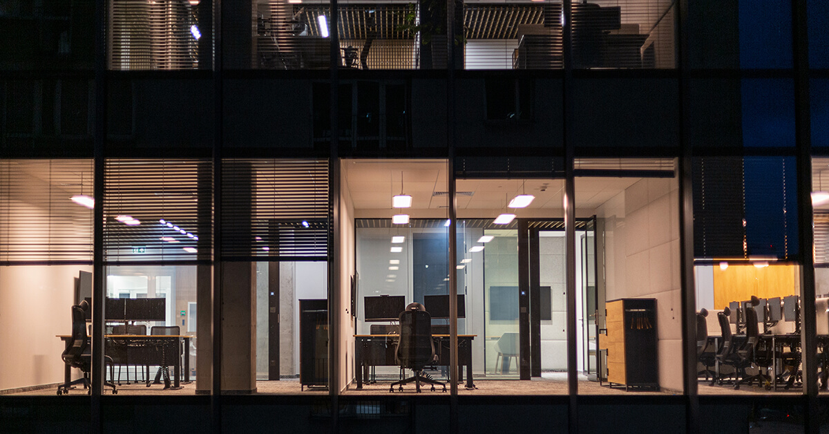 Empty office at night with illuminated workstations, representing gaps in after-hours IT coverage and availability.