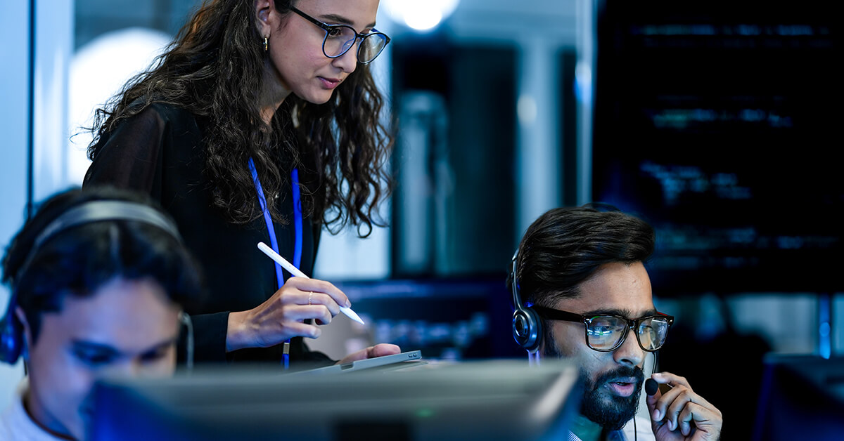 IT support professionals working together at a help desk to assist users and resolve technical issues.